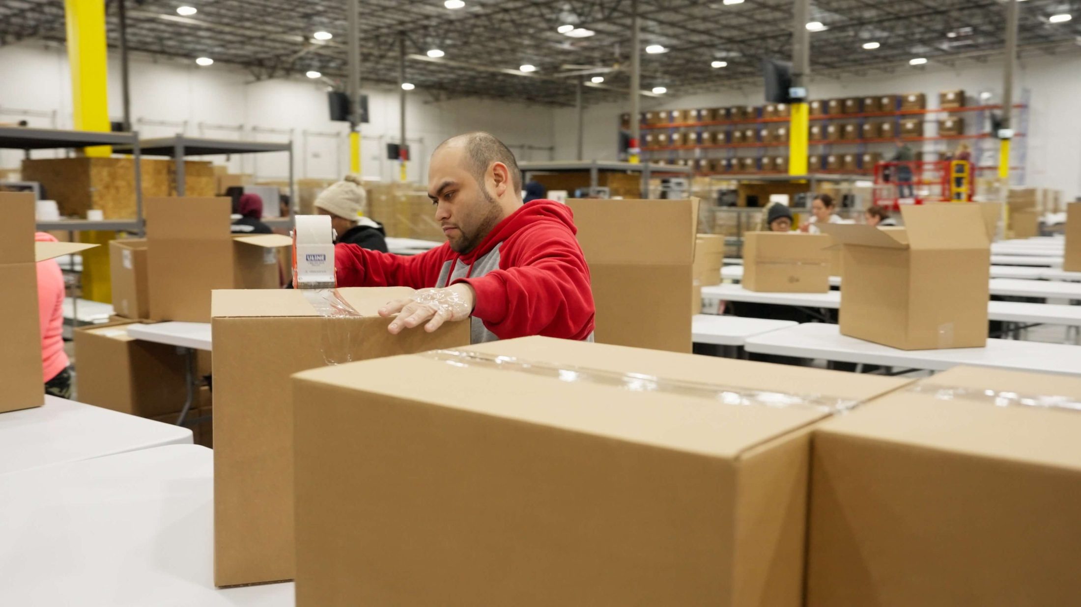 ZonPrep team member packing and labeling cartons at a prep bench